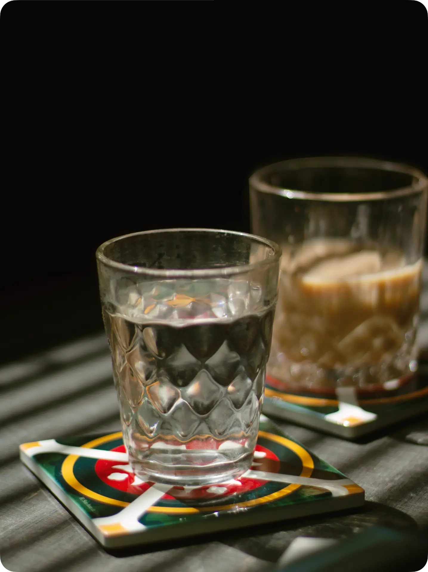 Vasos sobre posavasos PisoVaso con luz de tarde y sombras