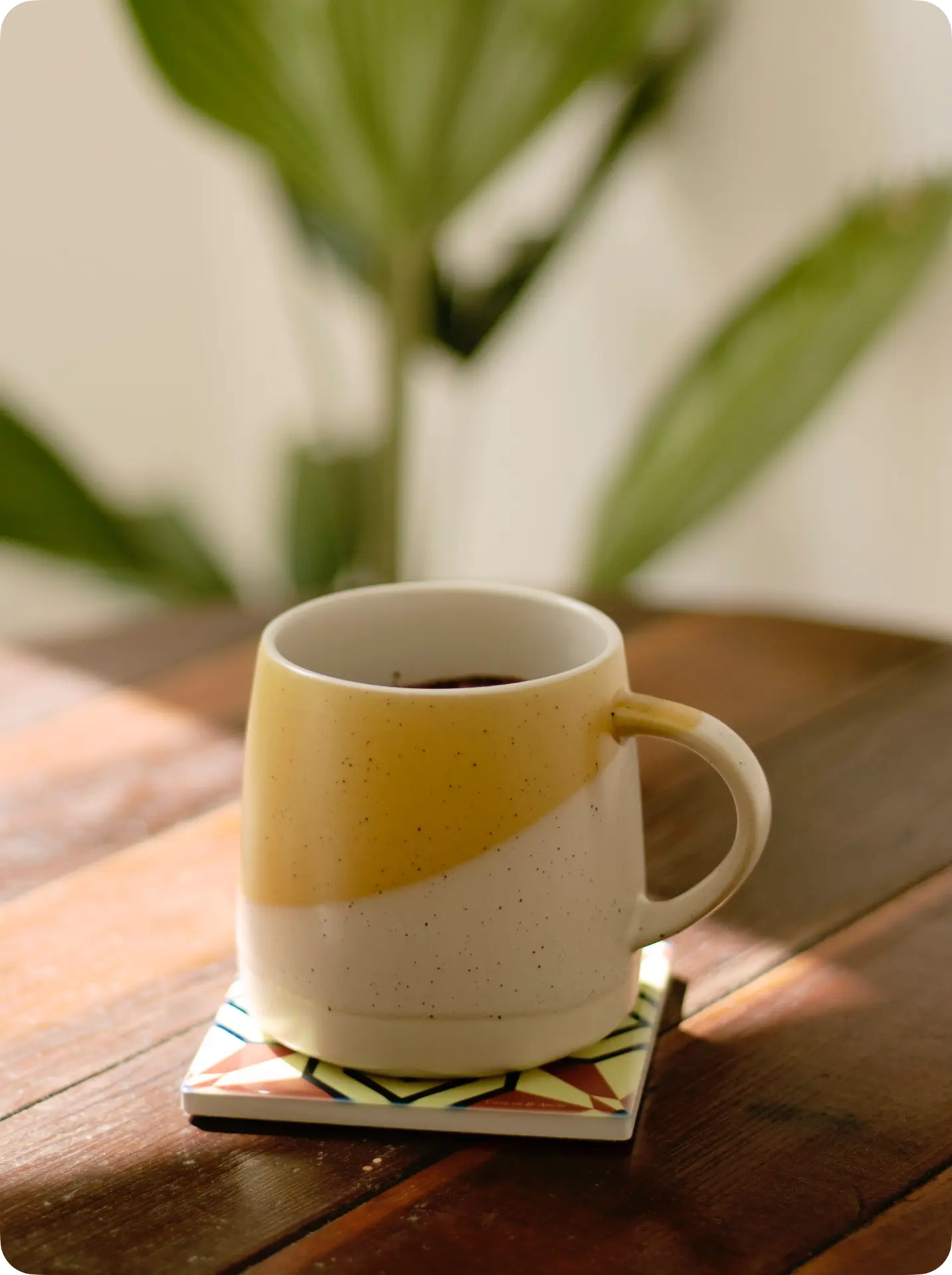Taza de café sobre un posavasos PisoVaso en una mesa de madera